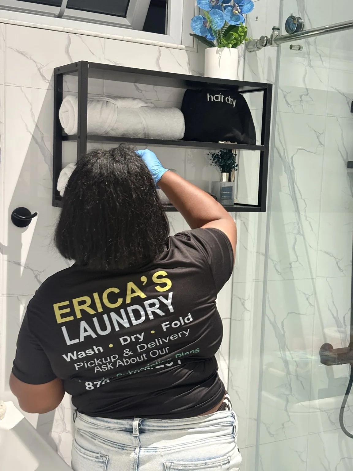 ELCS team member cleaning and preparing a bathroom shelf